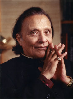 Image of Dr. Singha sitting in a black outfit with his fingers intercrossed in front of his face.